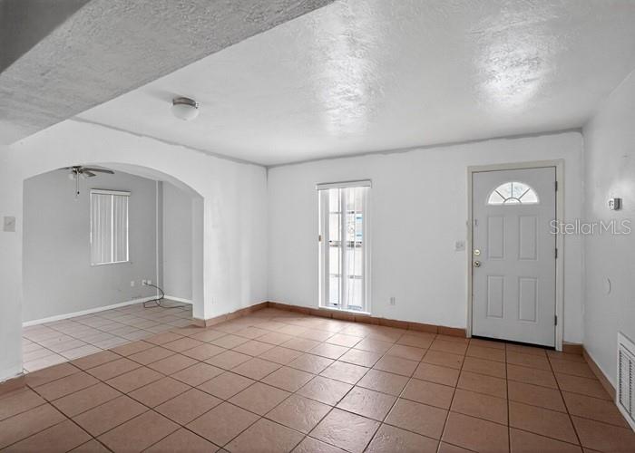 An interior view of a room with tiled flooring, white walls, and an arched entryway — 1668 W WAYCROSS CIRCLE, DELTONA, FL