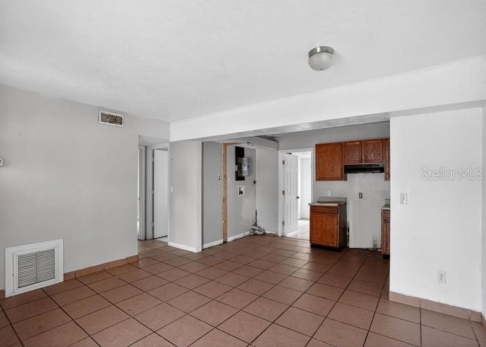An open-concept living and kitchen area features brown tile flooring and light gray walls — 1668 W WAYCROSS CIRCLE, DELTONA, FL