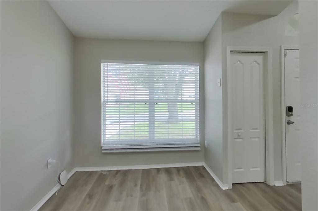 A room with light gray walls, wood-look flooring, a window with blinds, and a closet door — 3034 WENTWORTH PLACE, LAKELAND, FL