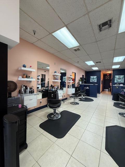 A hair salon interior features peach-colored walls, multiple styling stations with mirrors, and tiled flooring — 4609 Lake Worth Road # 4609, FL 33463, FL