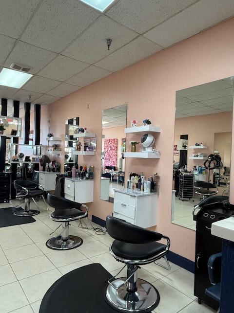 A hair salon features multiple styling stations with chairs, mirrors, and white storage cabinets — 4609 Lake Worth Road # 4609, FL 33463, FL