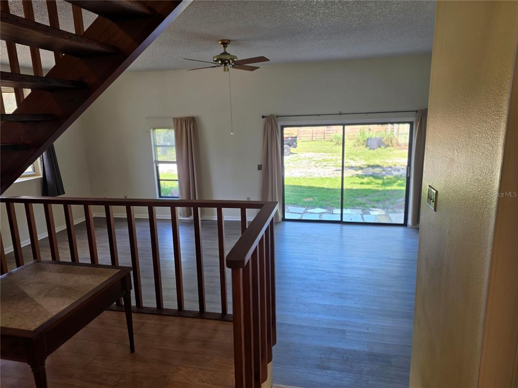 A kitchen features wood-grain cabinets, white appliances, beige countertops, and light-colored tile flooring — 4841 SUNDAY COURT, SARASOTA, FL