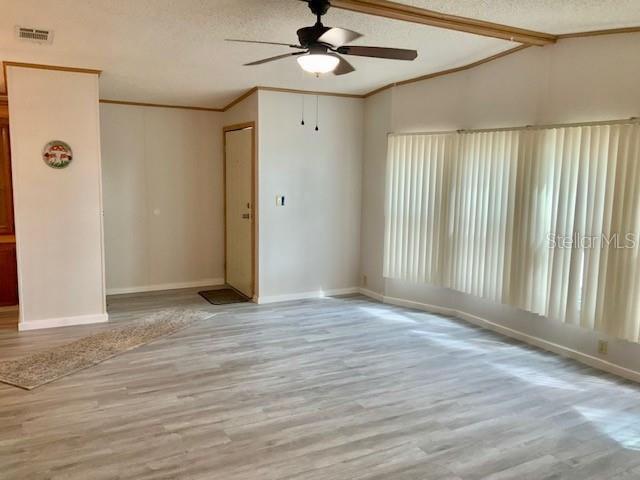 A living room features light wood-look flooring, a ceiling fan, and vertical blinds on windows — 13957 COUNTY ROAD 109D, LADY LAKE, FL