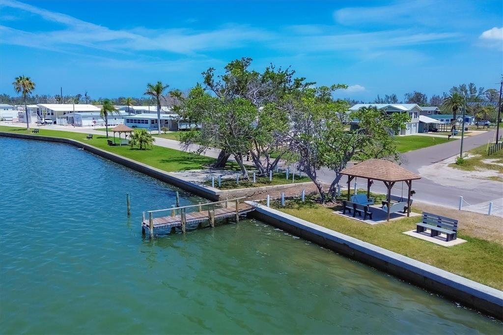 An aerial view shows a waterfront park with a wooden dock, gazebo, and benches — 4515 106TH STREET W, BRADENTON, FL