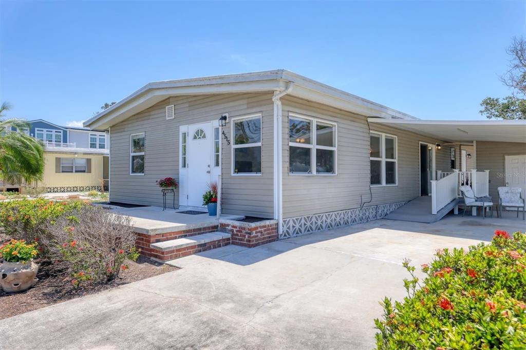A single-story house with light gray siding, a concrete driveway, and a covered carport — 4515 106TH STREET W, BRADENTON, FL