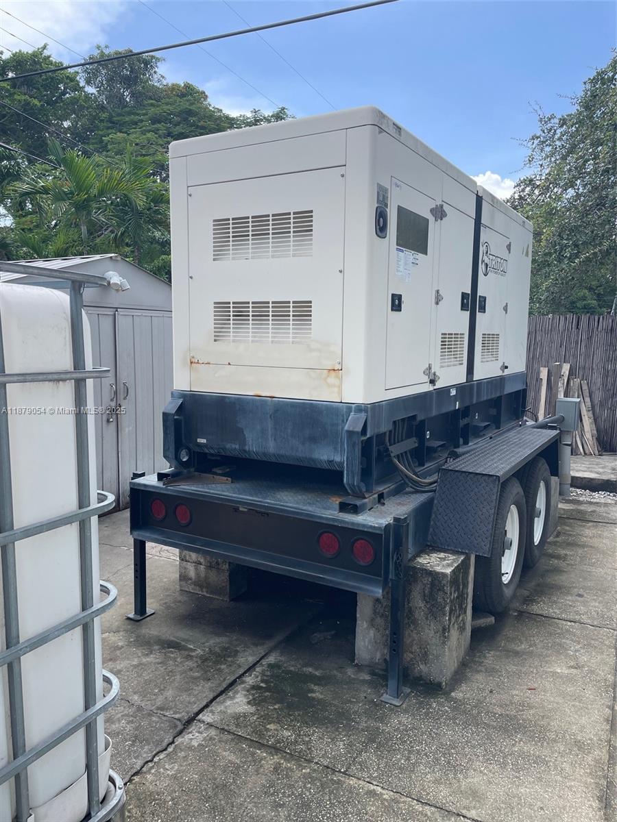 A large white industrial generator sits on a trailer parked on a concrete surface — 7228 Biscayne Blvd, Miami FL 33138, MIAMI, FL