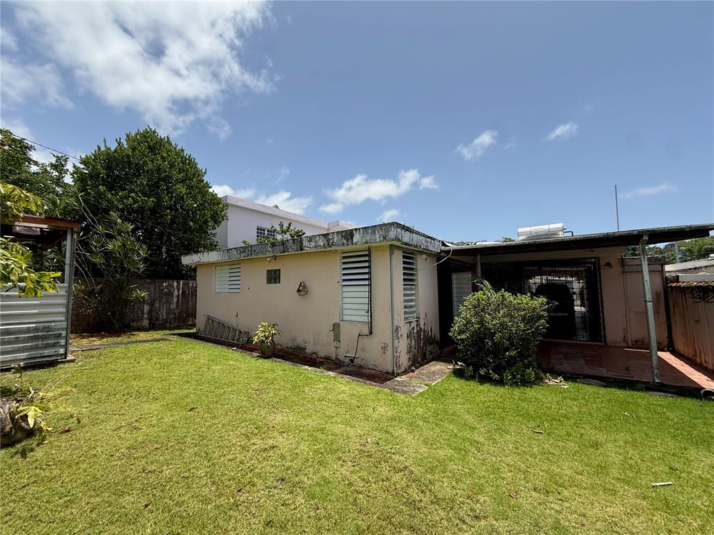 A single-story house with a flat roof, stucco walls, and a covered patio area — 1771 ALCALÁ, SAN JUAN, PR