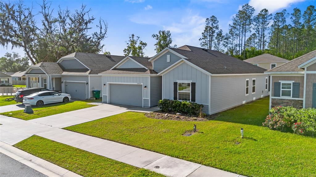 A view of the exterior of a light blue suburban house with a two-car garage — 24429 NW 7TH LANE, NEWBERRY, FL
