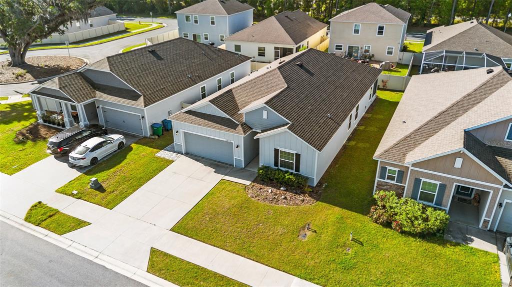 An aerial view shows suburban houses with driveways, green lawns, and dark shingled roofs — 24429 NW 7TH LANE, NEWBERRY, FL
