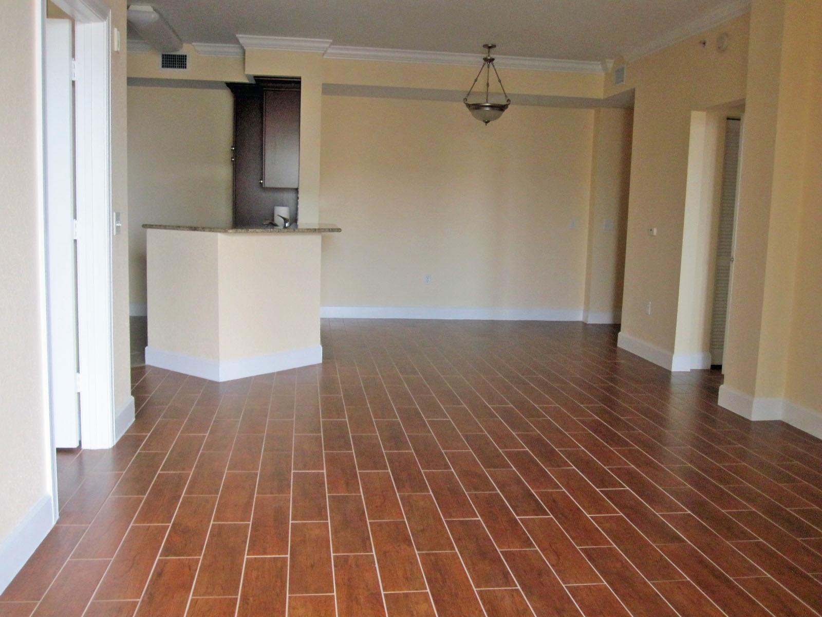 An empty room with wood-look tile flooring, a kitchen island, and a hanging light fixture — 1690 Renaissance Commons Boulevard # 1629, Boynton Beach FL 33426, BOYNTON BEACH, FL