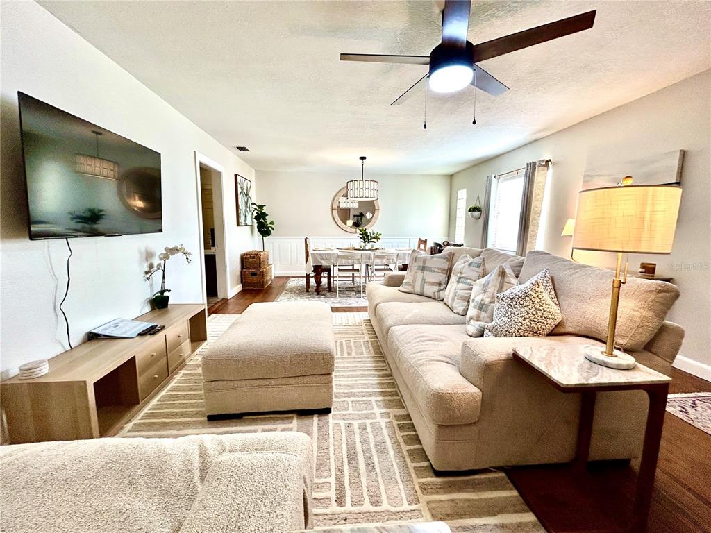 A living room features a large sectional sofa, a television, and an adjacent dining area — 265 W BAY AVENUE, LONGWOOD, FL