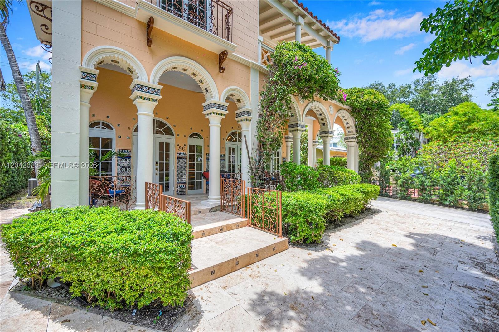 The exterior of a Mediterranean-style home features arched entryways, decorative tile work, and stone steps — 30 NE 44th St, Miami FL 33137, MIAMI, FL
