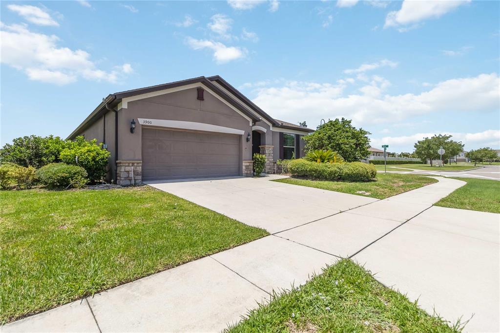 A single-story house with a beige stucco exterior, stone accents, and a two-car garage — 3900 BAJA DRIVE, ST CLOUD, FL