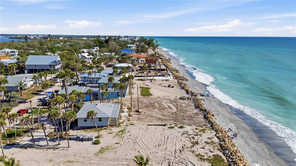 An aerial view shows beachfront houses situated along a sandy coastline next to the ocean — 4076 N BEACH ROAD UNIT CTG6, ENGLEWOOD, FL