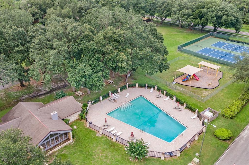 An aerial view shows a community swimming pool, a playground, and a clubhouse building — 3711 NW 56TH LANE, GAINESVILLE, FL