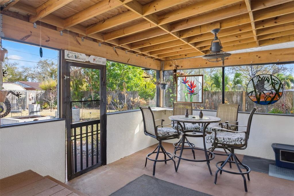 A kitchen features wood cabinets, granite countertops, a dark tile backsplash, and stainless steel appliances — 1023 N BASK DRIVE, TAMPA, FL