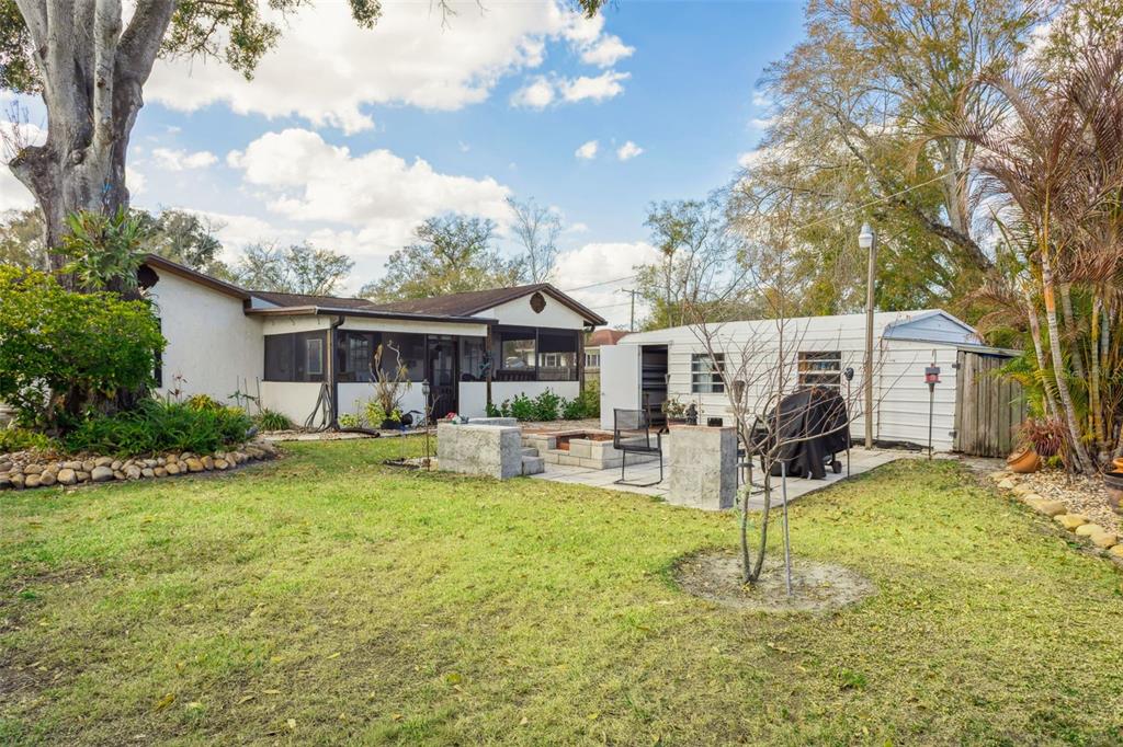 A screened-in porch features a wooden beamed ceiling, a dining set, and backyard views — 1023 N BASK DRIVE, TAMPA, FL