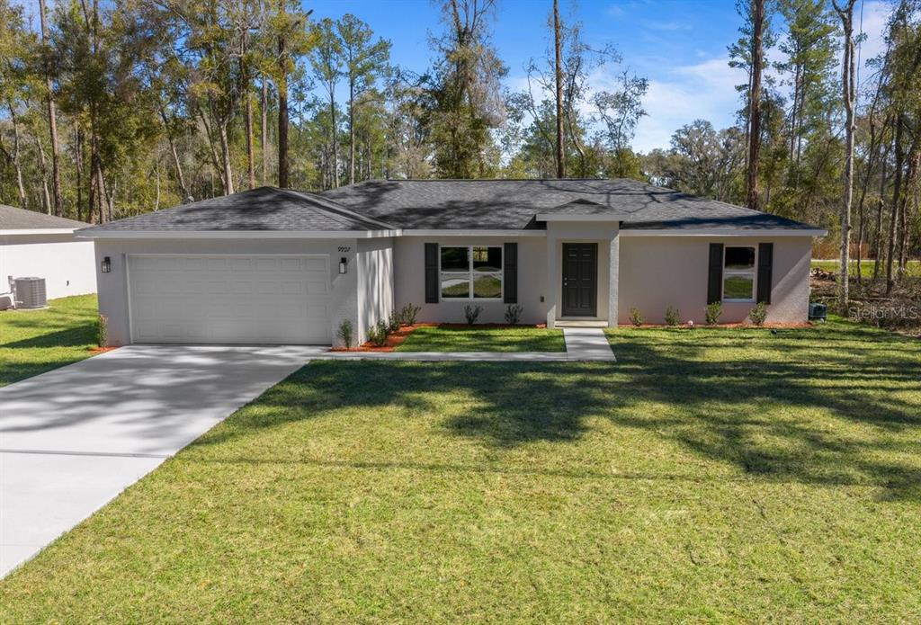 A single-story house with a two-car garage, gray exterior, and dark shutters — 9927 N ATHENIA DRIVE, CITRUS SPRINGS, FL