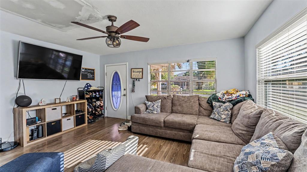 A living room with a sectional sofa, armchair, and an open kitchen with bar seating — 861 E LOWELL STREET, LAKELAND, FL