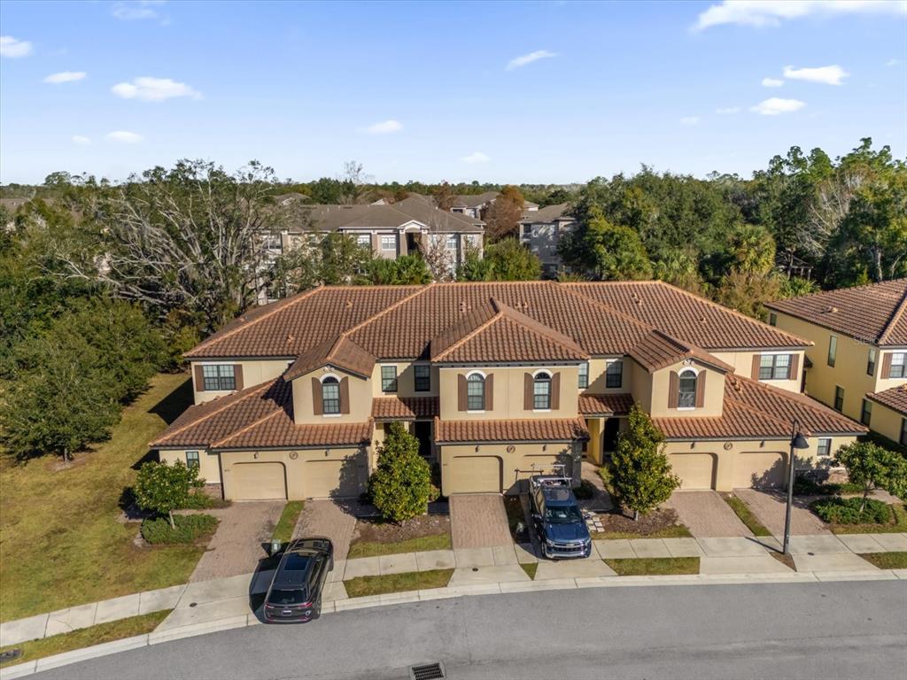 An aerial view of a multi-unit townhouse building with a tiled roof and attached garages — 8121 ROSEVILLE BOULEVARD, DAVENPORT, FL