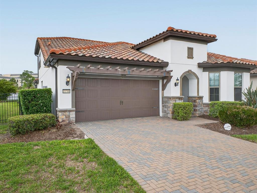 A single-story house with a brown garage door, tiled roof, and a paved driveway — 11708 MEADOW GROVE CIRCLE, ORLANDO, FL