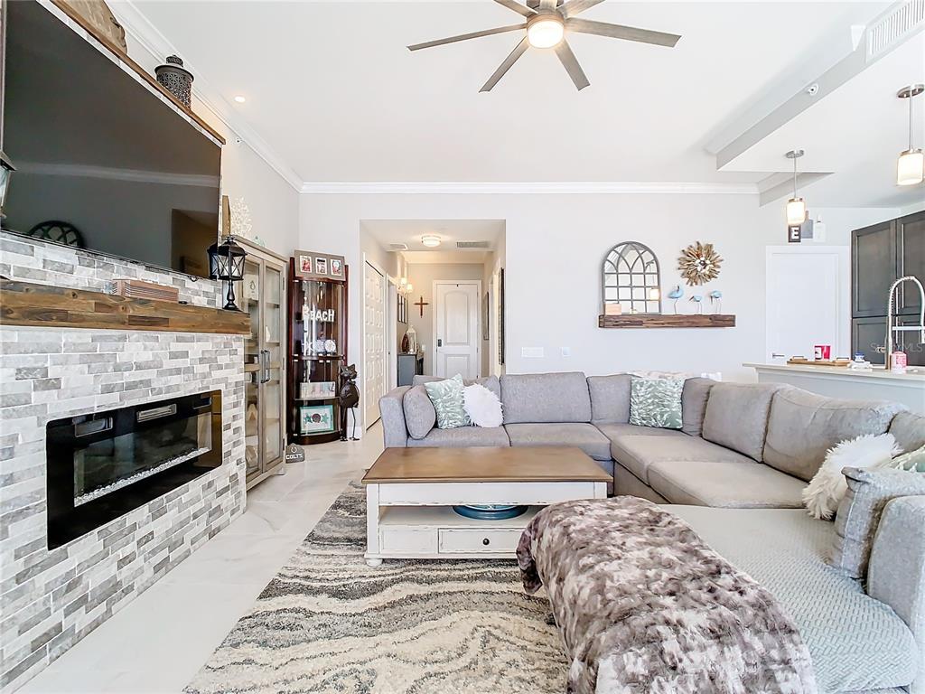 A living room features a stone fireplace, a gray sectional sofa, and a coffee table — 16300 COUNTY ROAD 455 UNIT 610, MONTVERDE, FL