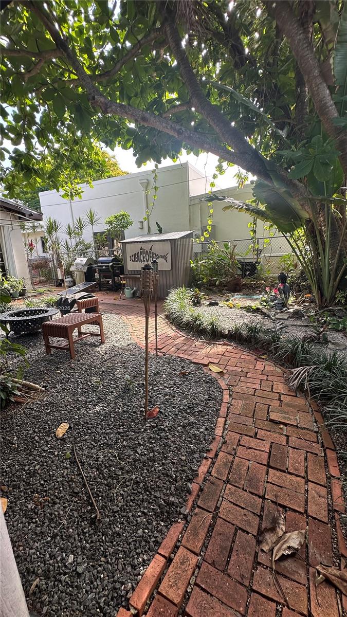 A backyard features a brick pathway, gravel ground, a small shed, and a fire pit — 5804 SW 35th St # 0, Miami FL 33155, MIAMI, FL