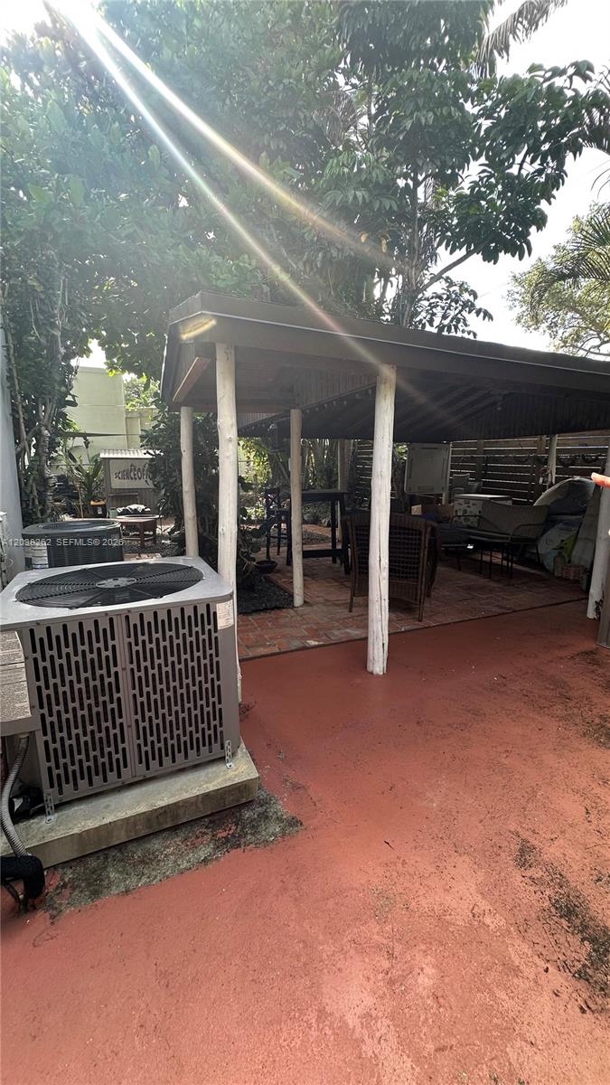 A backyard patio features a covered seating area with white posts and brick flooring — 5804 SW 35th St # 0, Miami FL 33155, MIAMI, FL