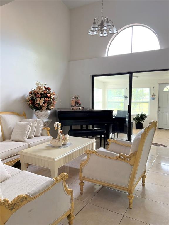 A kitchen with white cabinets, stainless steel refrigerator, and reddish-brown tiled flooring — 499 CHICAGO WOODS CIRCLE, ORLANDO, FL