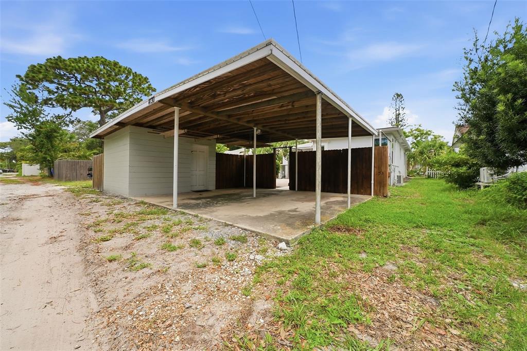 A carport with a concrete slab and an attached storage room sits beside a house — 4730 BURLINGTON AVENUE N, ST PETERSBURG, FL