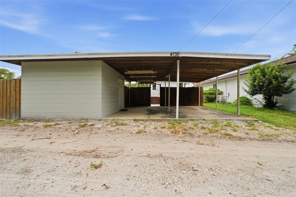 A wide carport with a flat roof and a concrete floor sits in front of a house — 4730 BURLINGTON AVENUE N, ST PETERSBURG, FL