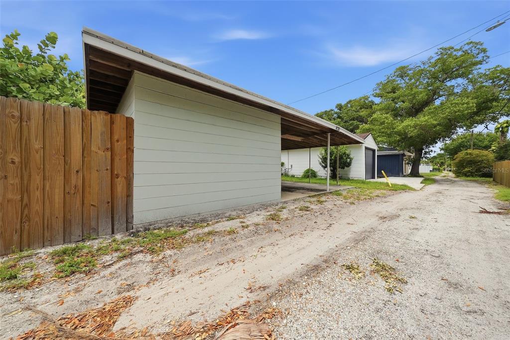 A side view of a house with a carport and a wooden fence — 4730 BURLINGTON AVENUE N, ST PETERSBURG, FL