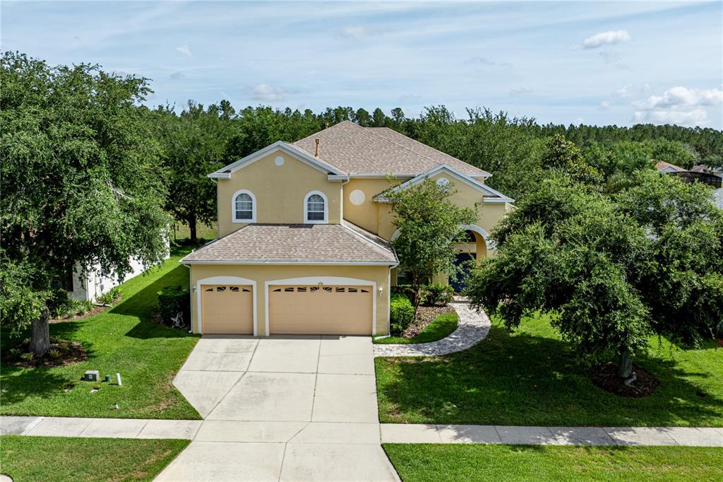 A two-story tan house with a two-car garage and a blue front door — 2718 KNIGHTSBRIDGE ROAD, CLERMONT, FL