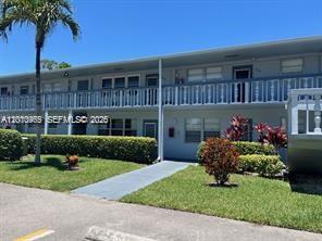 A two-story apartment building features a white exterior, a balcony, and a manicured lawn — 172 Prescott I # 172, Deerfield Beach FL 33442, DEERFIELD BEACH, FL