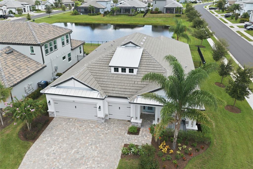 An aerial view of a single-story house with a tiled roof, garage, and paver driveway — 4815 HONEY DEW LANE, BRADENTON, FL