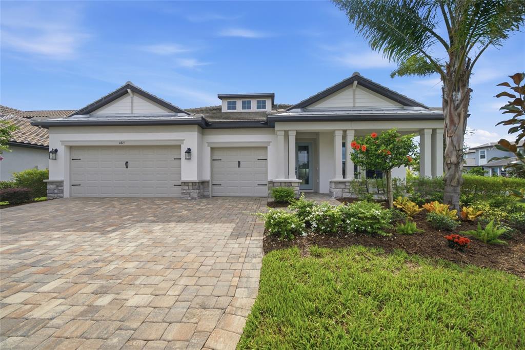 A single-story house with a paved driveway, two-car garage, and a covered front porch — 4815 HONEY DEW LANE, BRADENTON, FL