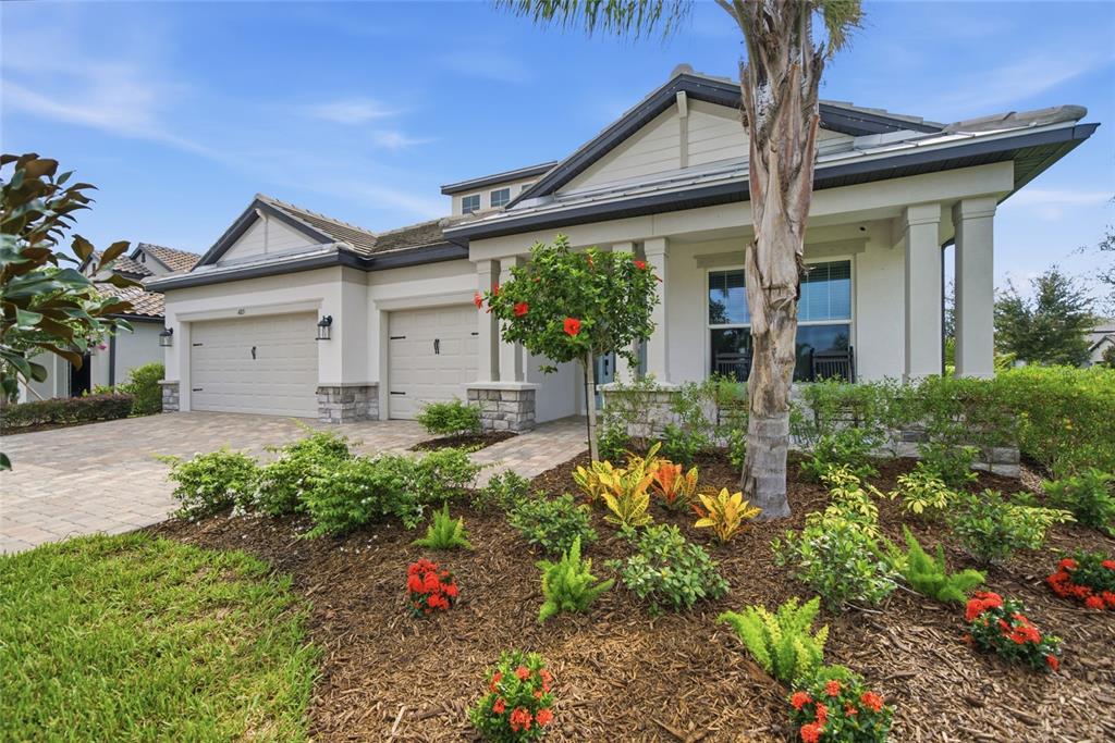 A single-story house with a two-car garage, stone accents, and a landscaped front yard — 4815 HONEY DEW LANE, BRADENTON, FL