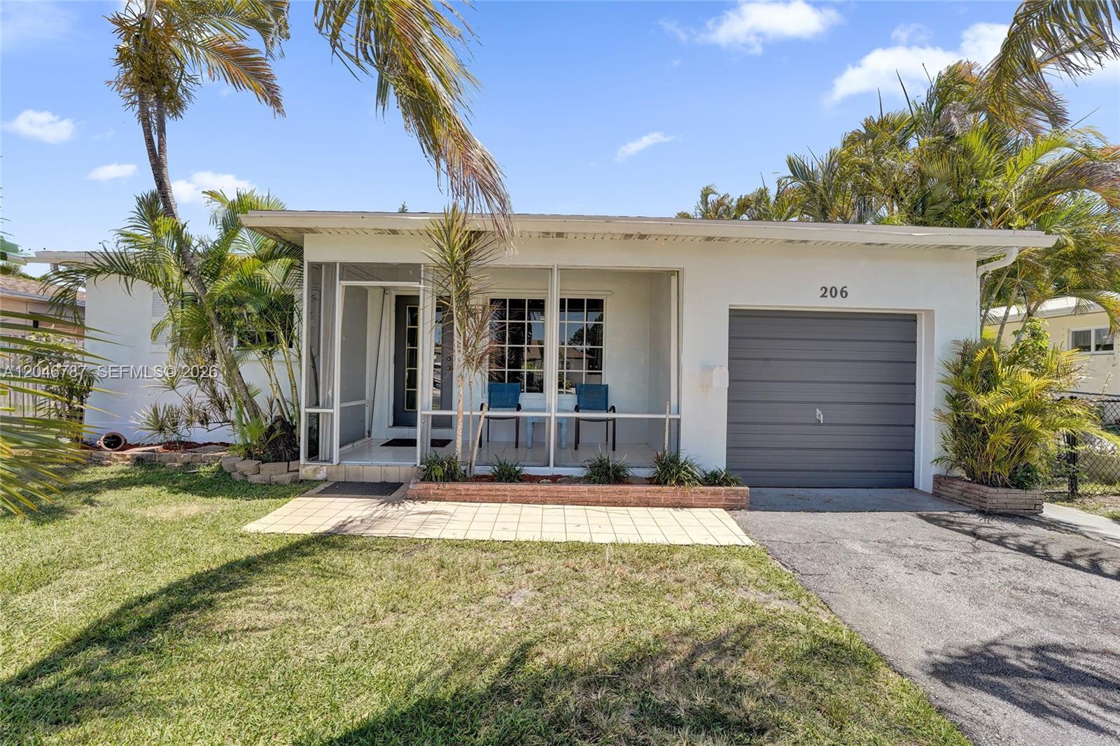 A single-story house with a screened front porch, a garage, and palm trees — 206 SE 3rd St, Dania Beach FL 33004, DANIA BEACH, FL