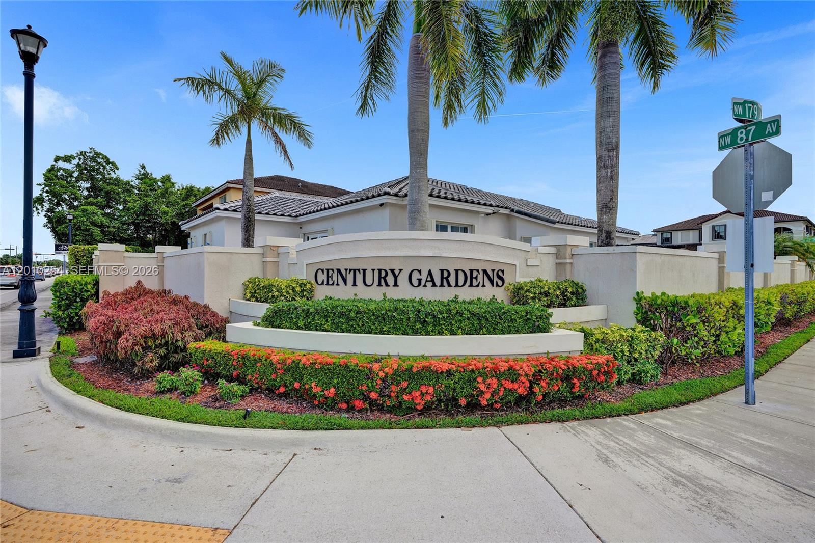 A stone monument sign for Century Gardens stands in front of a house with palm trees — 17951 NW 91st Ct, Hialeah FL 33018, HIALEAH, FL
