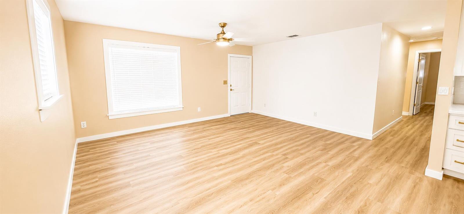An empty room with light wood-look flooring, tan walls, a ceiling fan, and white trim — 3095 NW 36th Street, Okeechobee FL 34972, OKEECHOBEE, FL