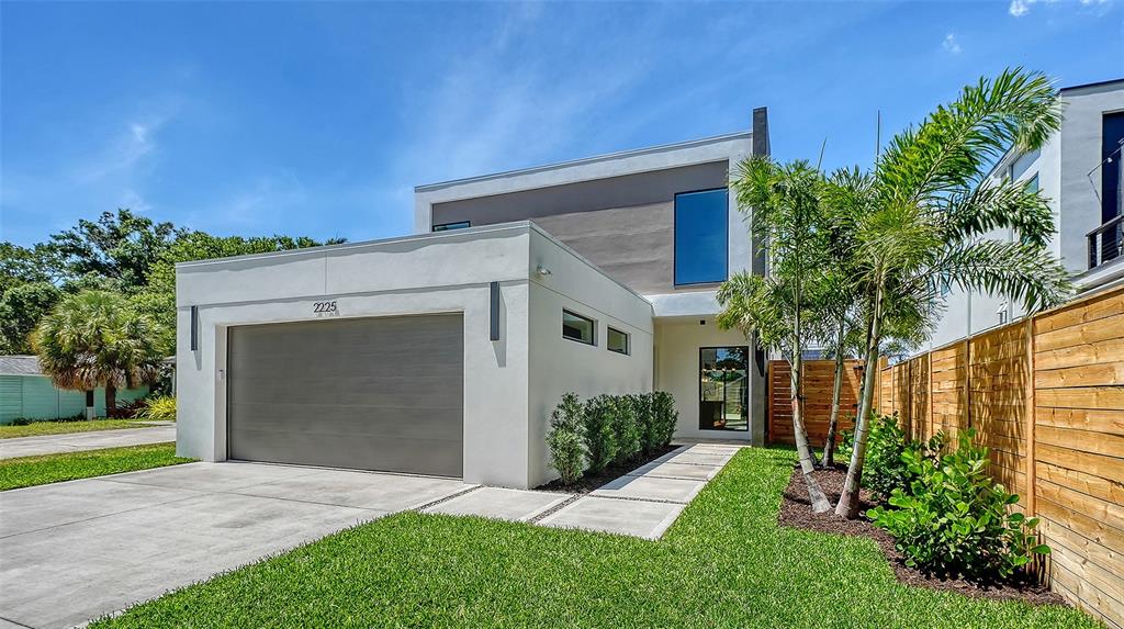 A modern two-story house features a flat roof, a garage, and a wooden fence — 2225 FLORINDA STREET, SARASOTA, FL