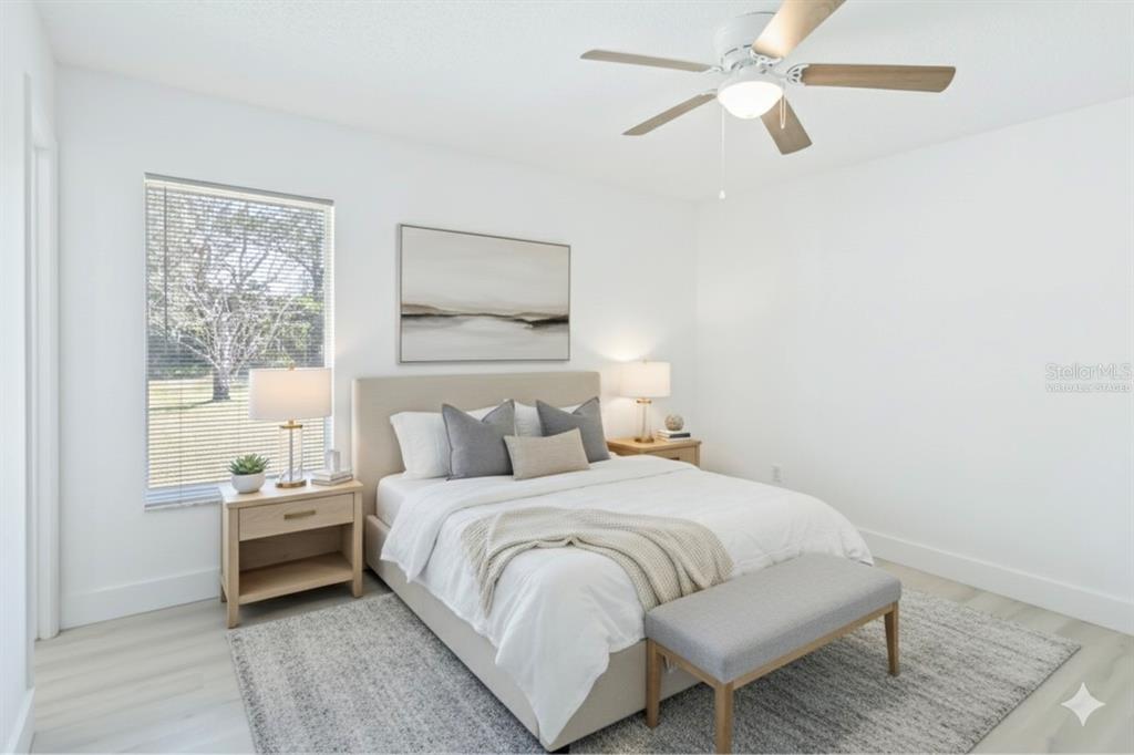 A bedroom with a bed, two nightstands, a ceiling fan, and a window with blinds — 11407 SPLITWOOD LANE, ORLANDO, FL