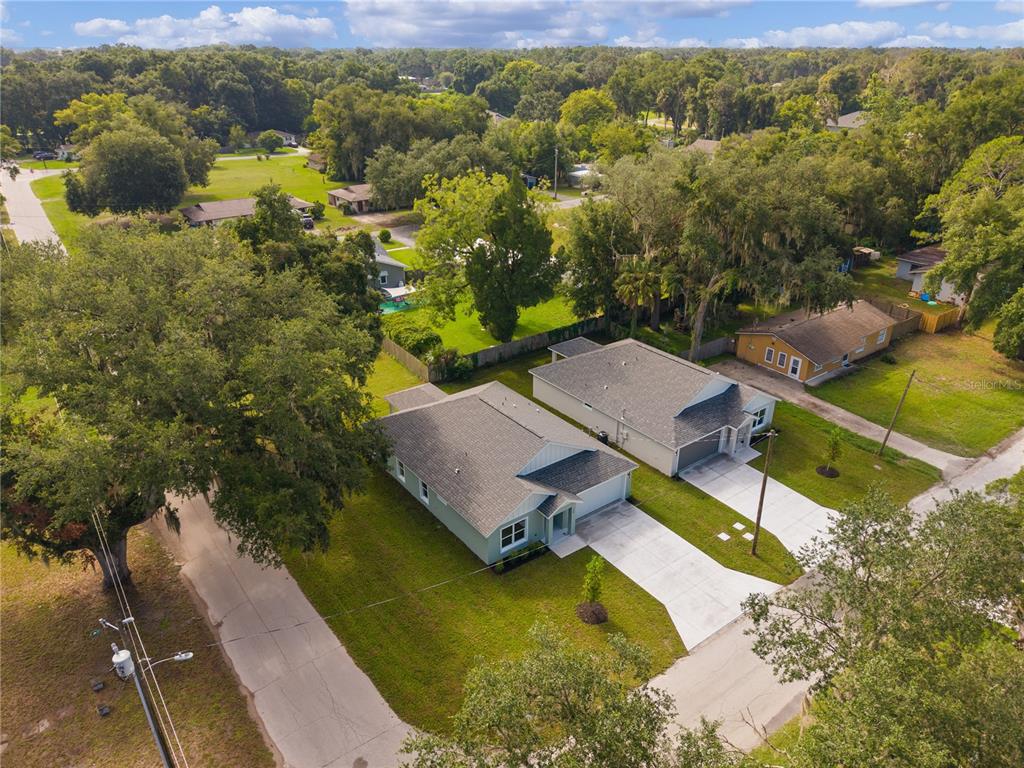 An aerial view shows two modern single-story houses with gray roofs and concrete driveways — 768 POWELL STREET, WILDWOOD, FL