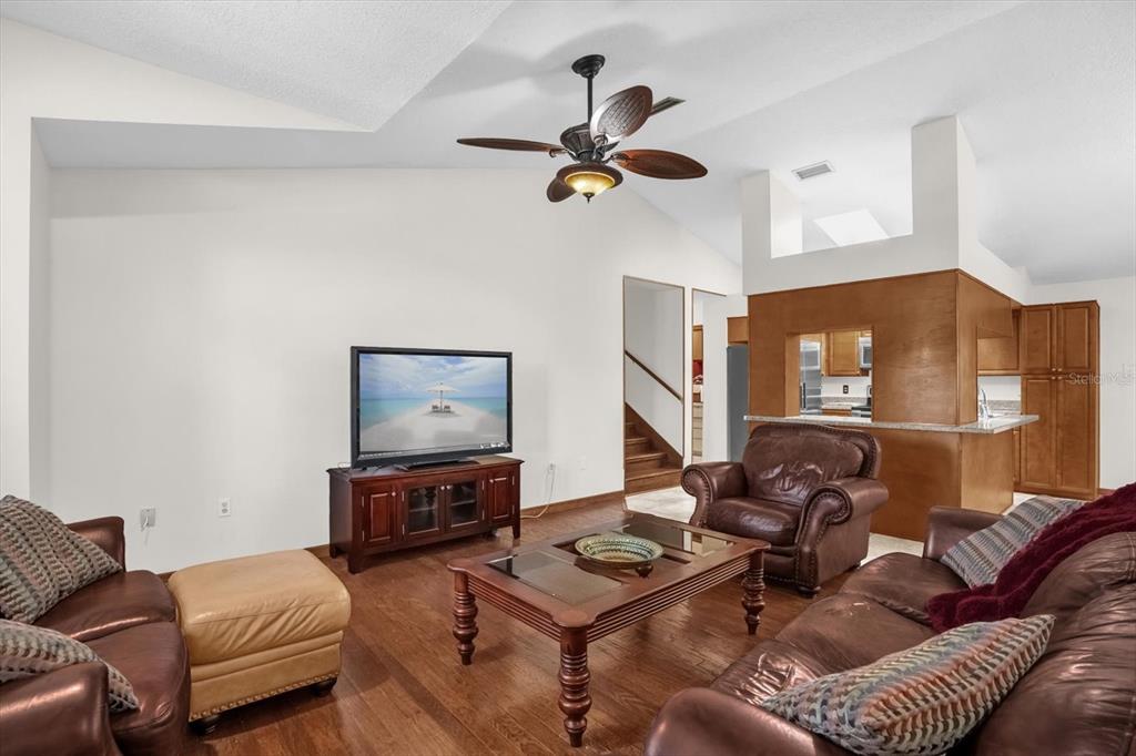 A living room features leather furniture, a wooden coffee table, and a vaulted ceiling — 3500 SAIL FISH AVENUE, FRUITLAND PARK, FL