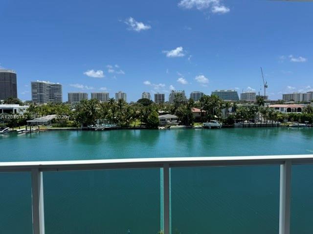 A view of a canal with palm trees and high-rise buildings in the background — 9381 E Bay Harbor Dr # 404S, Bay Harbor Islands FL 33154, BAY HARBOR ISLANDS, FL