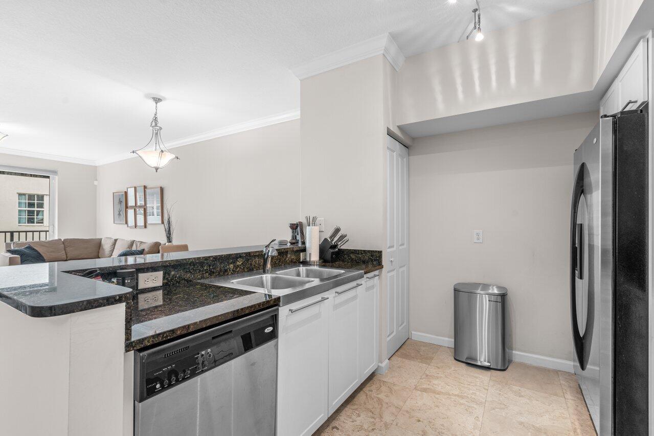 A kitchen features granite countertops, white cabinets, stainless steel appliances, and tile flooring — 235 NE 1st Street # 504, Delray Beach FL 33444, DELRAY BEACH, FL