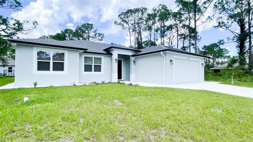 A light blue, single-story suburban house with a two-car garage and a grassy front yard — 3399 LA GOY STREET, NORTH PORT, FL