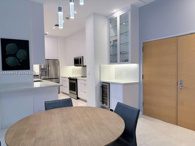 A living room features a white sectional sofa, glass coffee table, and floor-to-ceiling windows — 881 Ocean Dr # L2, Key Biscayne FL 33149, KEY BISCAYNE, FL