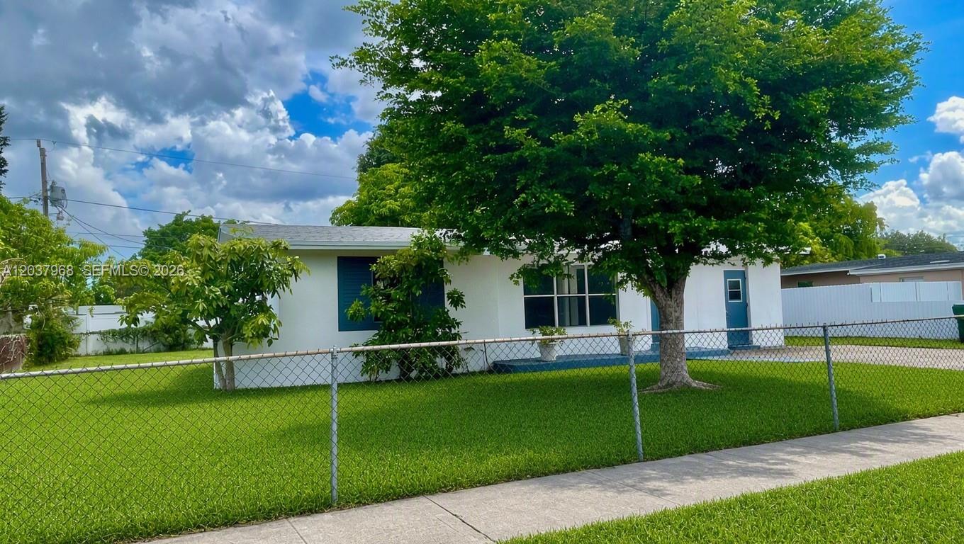 A white single-story house with blue shutters and a large tree in the front yard — 3460 NW 5th Ct, Lauderhill FL 33311, LAUDERHILL, FL