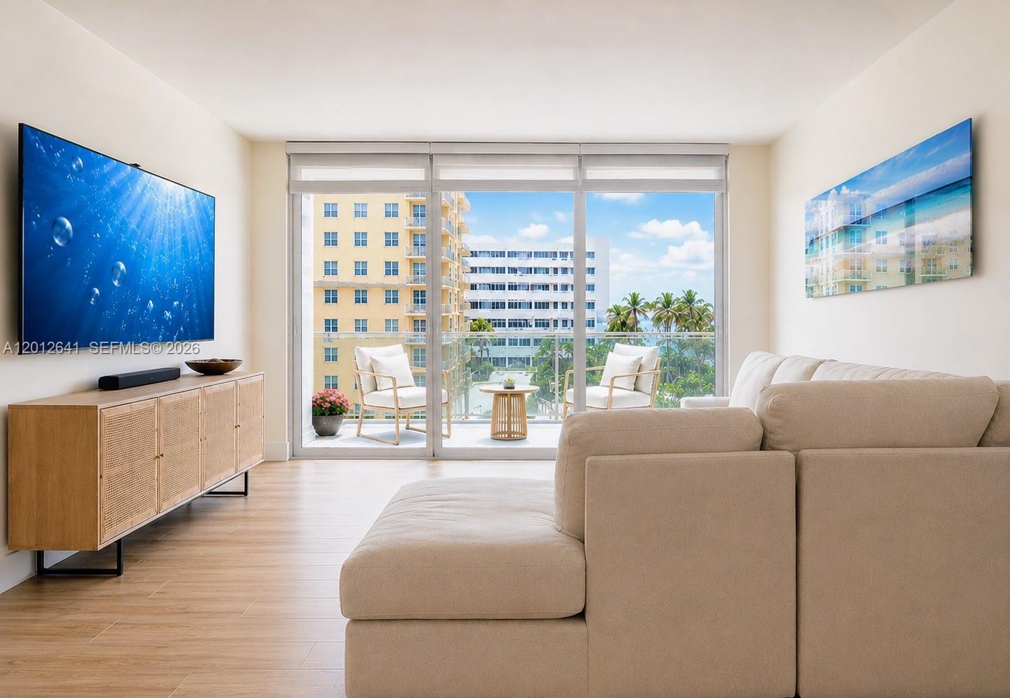 A living room features a beige sectional sofa, a wooden media console, and a balcony view — 2030 S Ocean Dr # 309, Hallandale Beach FL 33009, HALLANDALE BEACH, FL